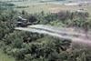 A UH- 1D helicopter from the 336th Aviation Company sprays a agent orange on a dense jungle area in the Mekong delta - Illustration