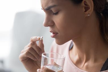 Woman taking a pain killer tablet