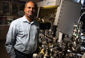 Vijay Murugesan standing next to lab equipment