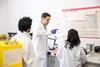 A scientist giving instructions to two other scientists in a lab