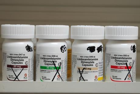 Medicine bottles on a pharmacy shelf marked as empty